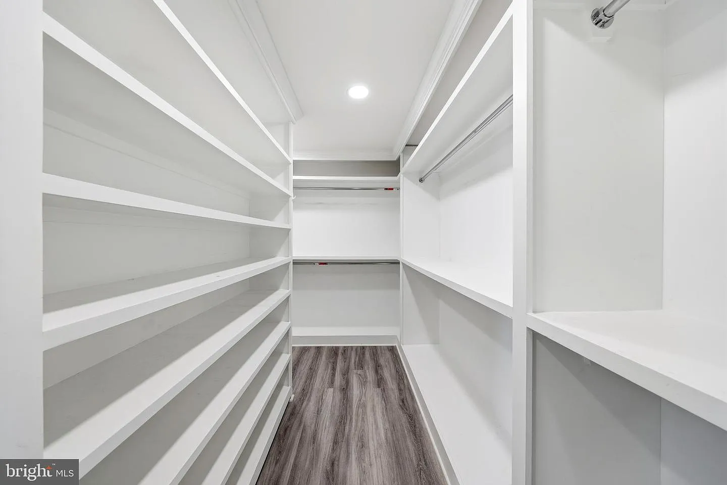 Open shelving lines one side for shoes and folded storage, while double rods maximize vertical space for wardrobe organization.