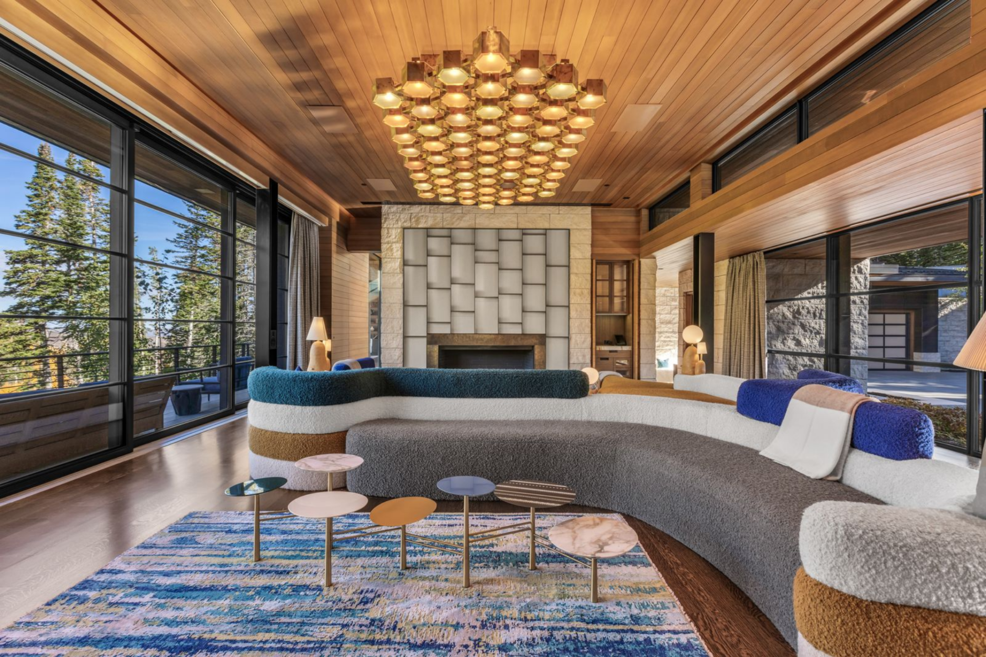 Opposite the windows, a contemporary fireplace lined in large-format stone creates another striking architectural detail for the room.