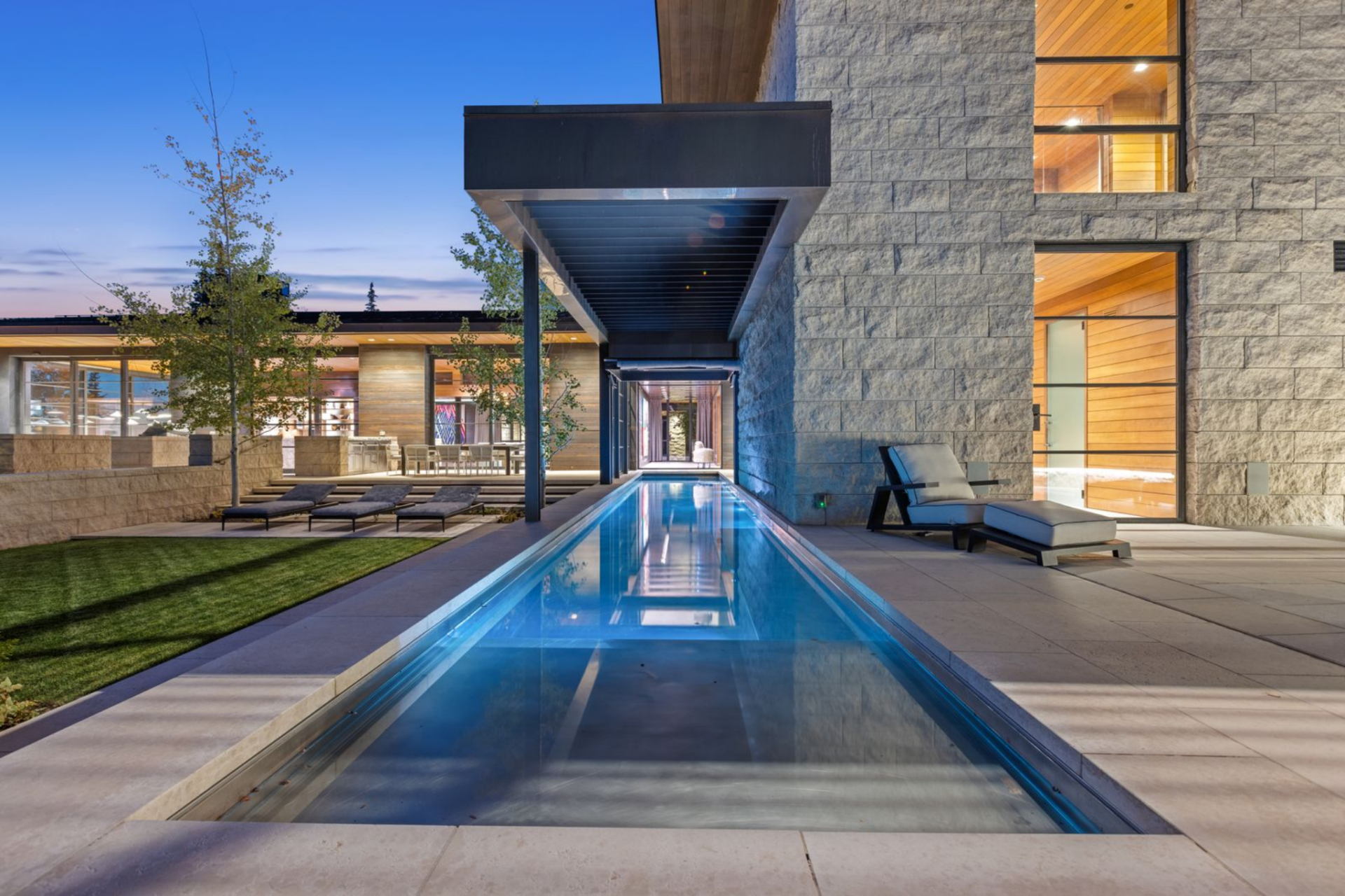 Retractable glass walls and covered overhangs blur the boundary between inside and out, transforming the pool into a year-round amenity.