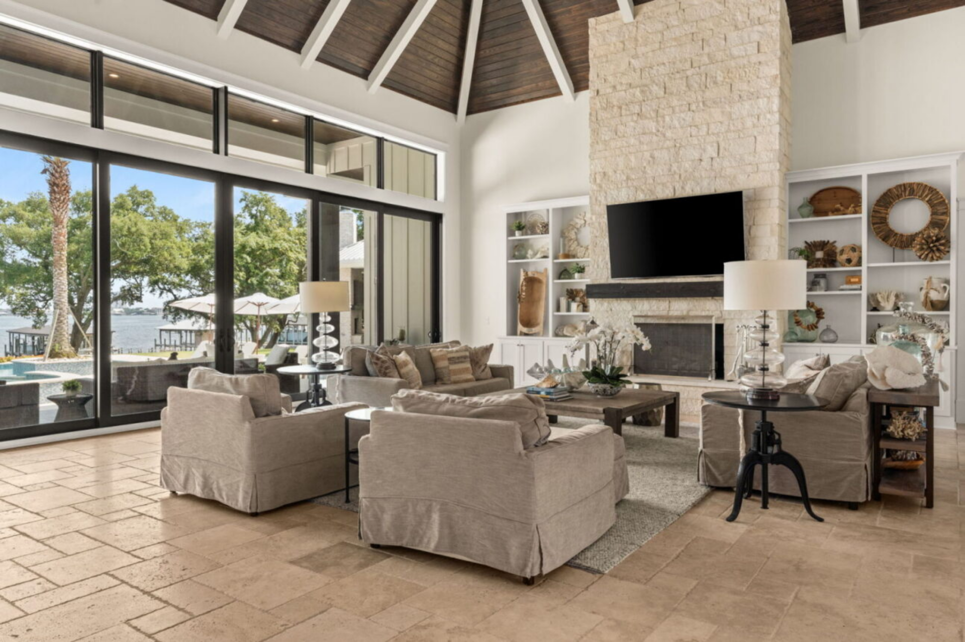 At the center of the room, a seating arrangement of neutral sofas and armchairs is arranged around a low coffee table, creating a comfortable gathering area.