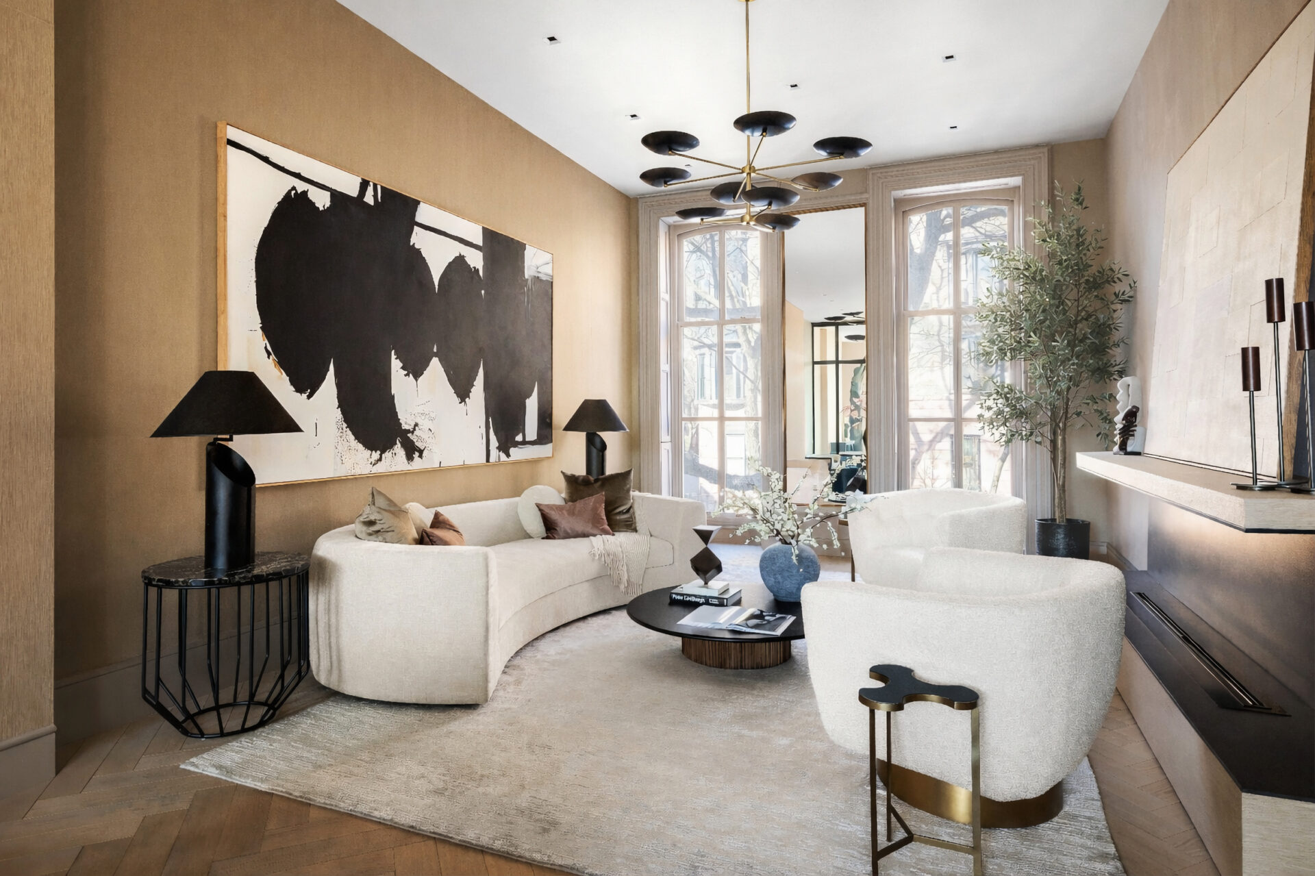 Off to the left of the foyer, the formal living room is arranged as a long sitting space, with a curved sofa and rounded lounge chairs centered on a large rug.