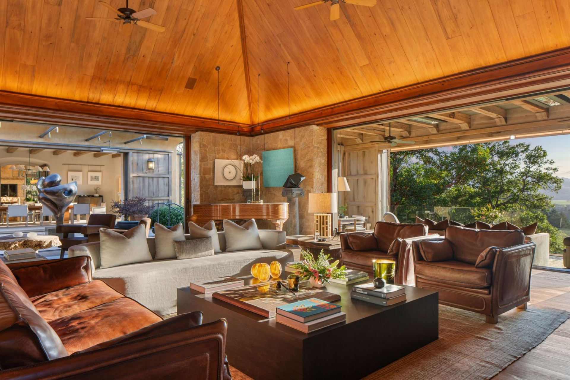 Inside, the living room is centered on a mix of limestone walls and reclaimed wood beams, giving the space its defining contrast. 