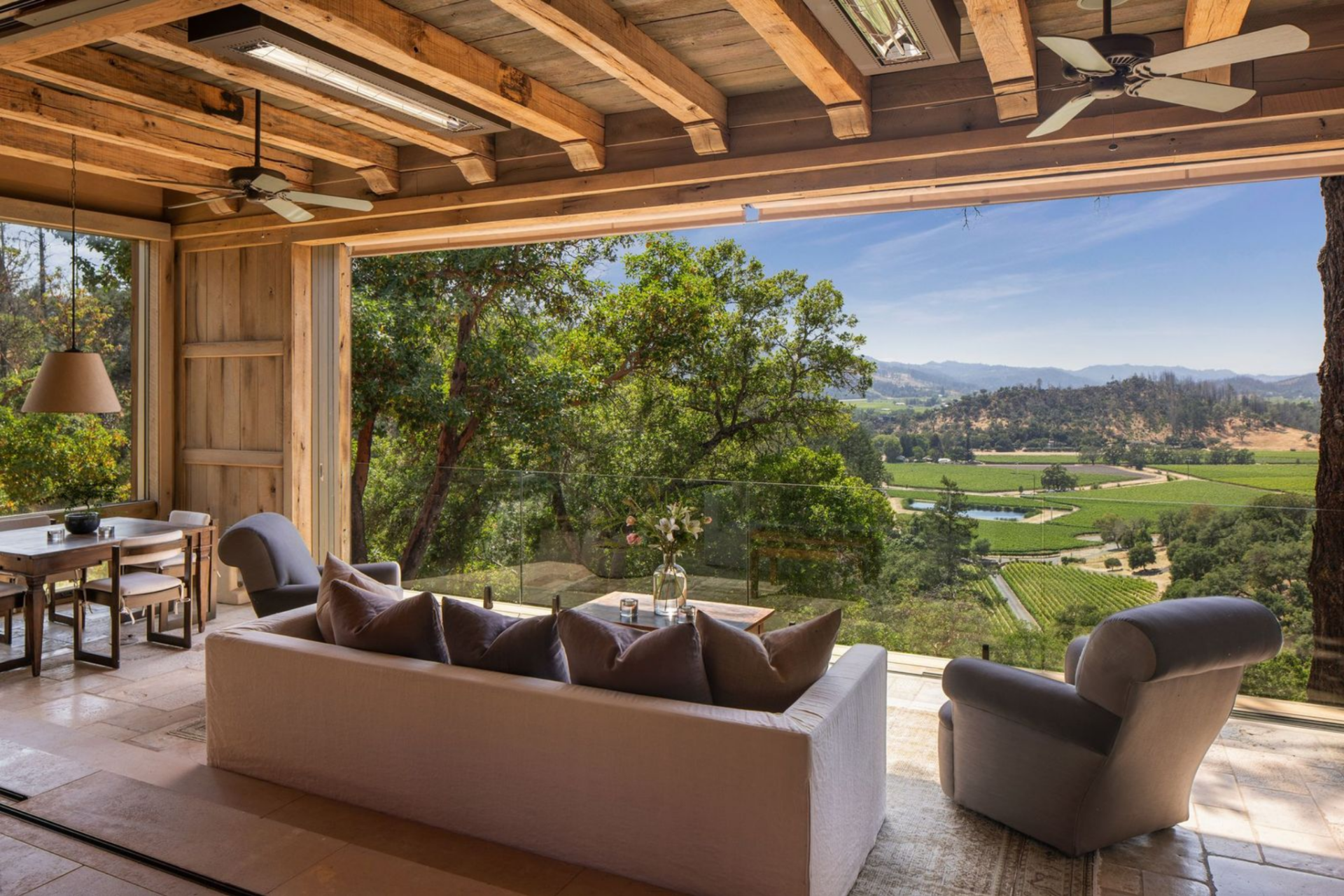 The layout continues outward through another set of pocket doors, opening the main living area to a covered outdoor living room at the edge of the house. 