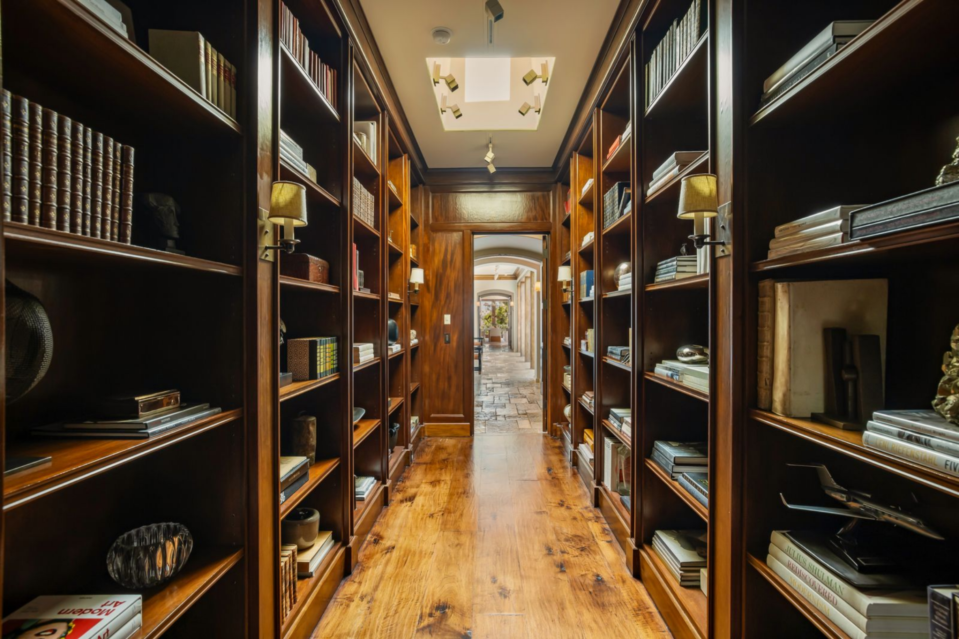 A skylight at the center brings light straight down the middle, brightening the books, objects, and display pieces.