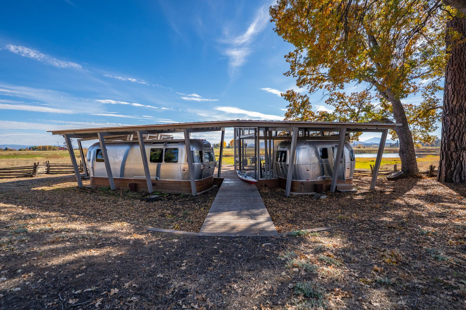 A separate Airstream camp introduces a more casual living setup, with multiple custom trailers configured around a shared outdoor deck. 