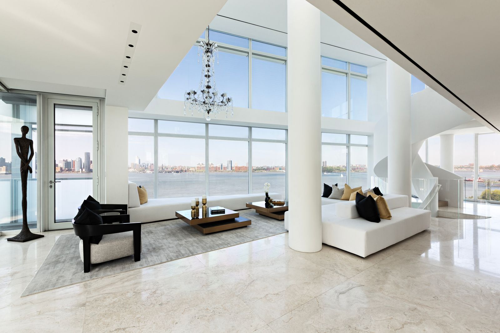 Above, a second row of windows pulls in additional light, emphasizing the full height of the room, while a chandelier hangs off to one side.