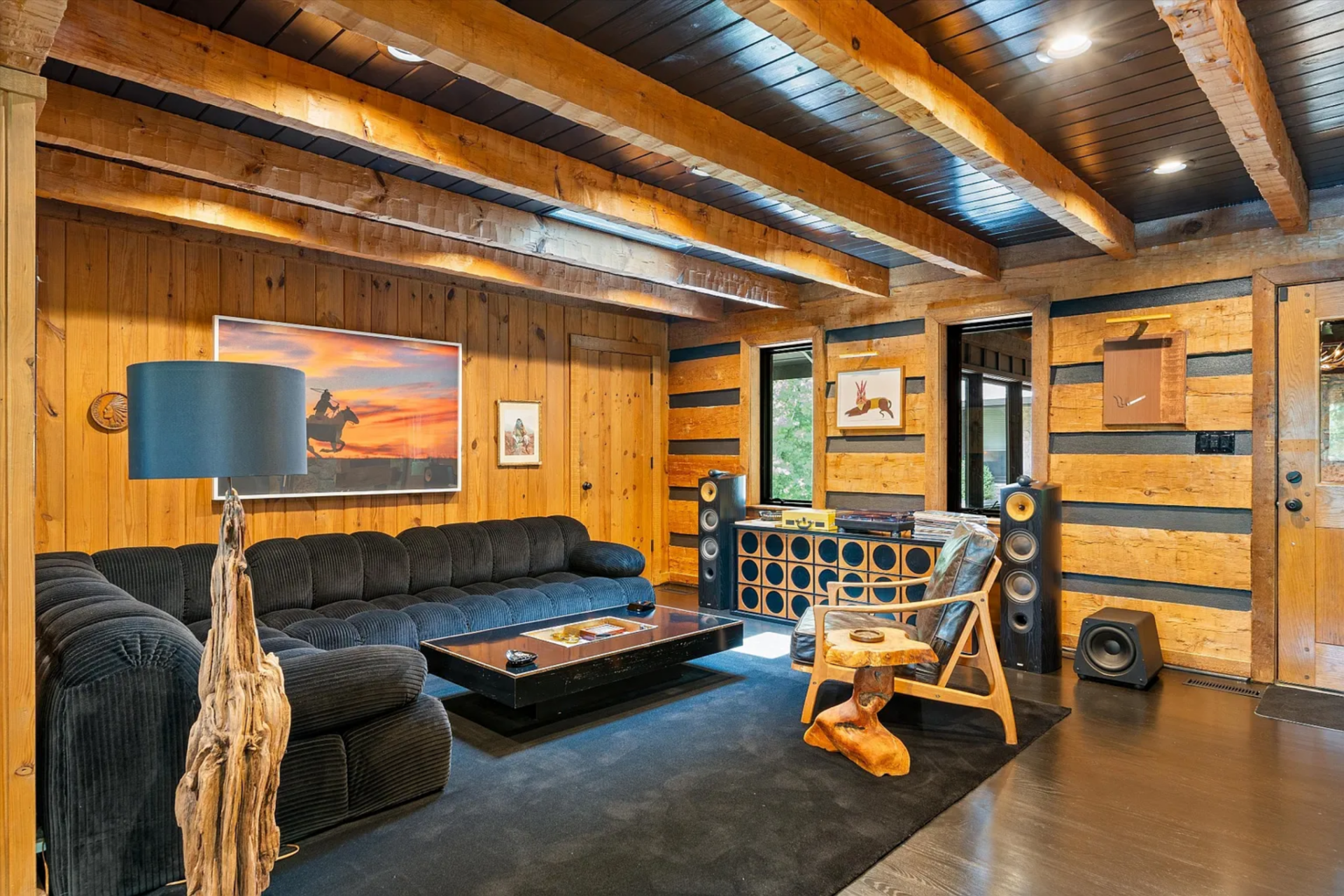 Off the main living areas, the family room consists of a deep sectional on one side of the room and built-in sound system, while a mix of wood, leather, and sculptural accent pieces.
