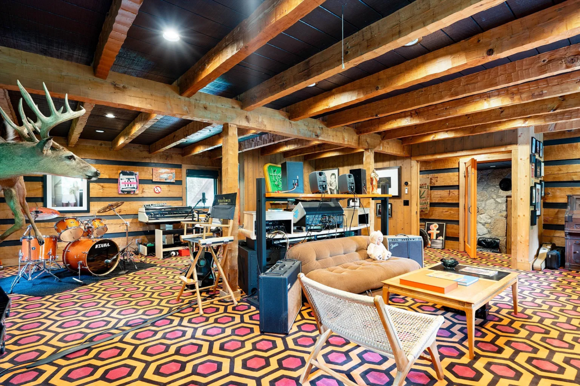 Farther into the house, the music studio is lined with a bold geometric carpet, with a variety of instruments, recording equipment, and casual seating.