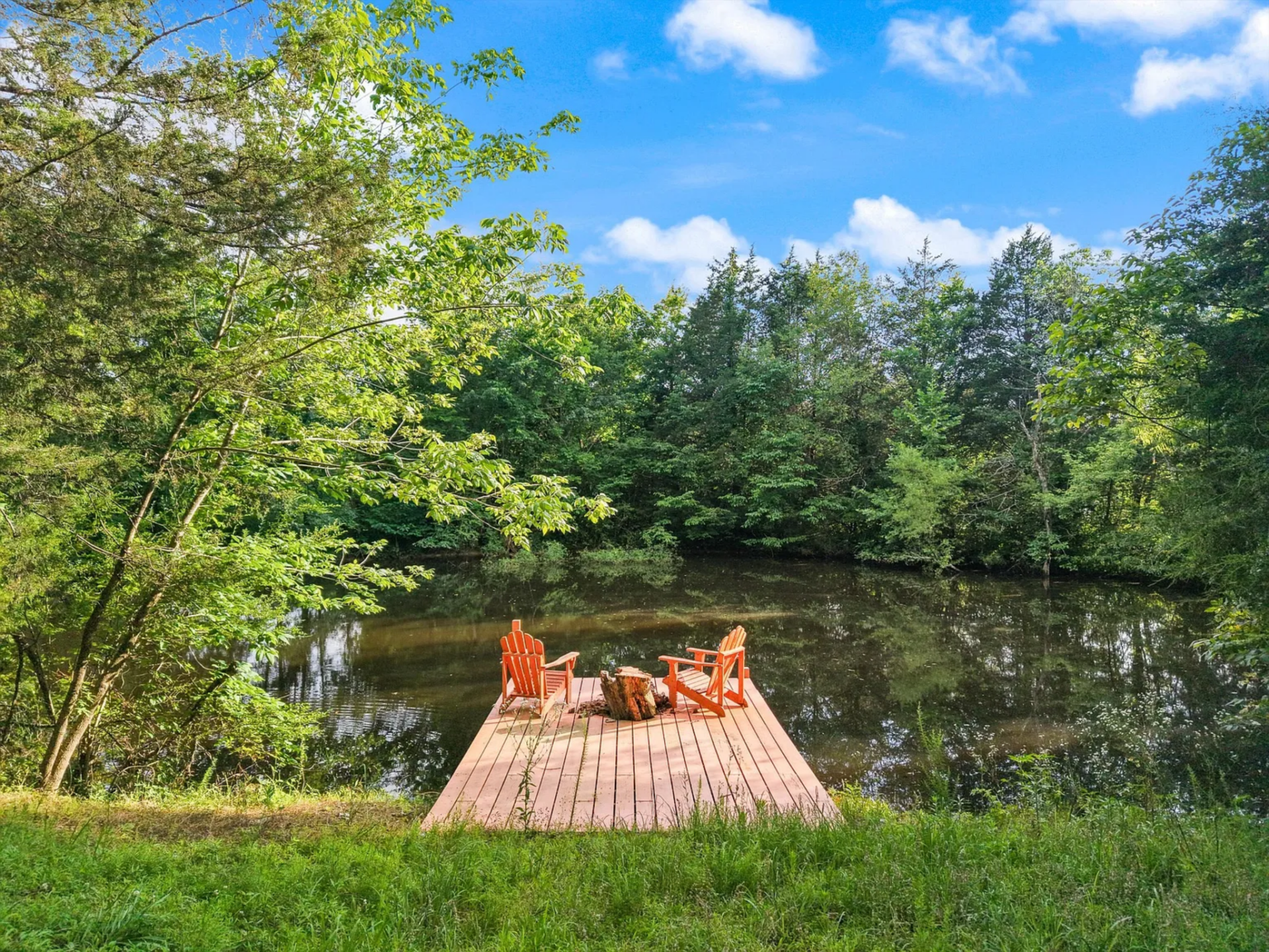 One is approached by a small dock with seating positioned right at the water’s edge, creating a quiet place to sit or fish. 