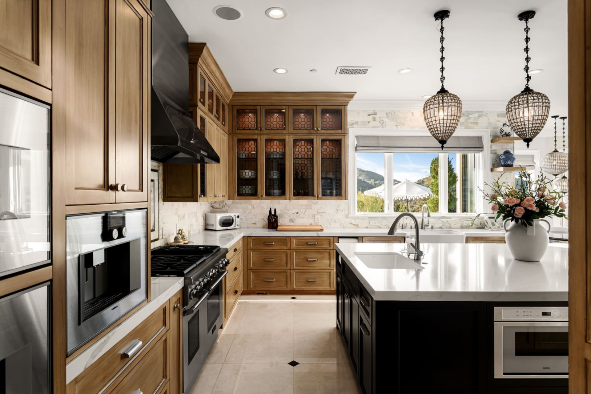 From the side angle, the working side of the kitchen comes into focus, with the range and built-in ovens set into the cabinetry and the island positioned as both prep space and casual seating. 