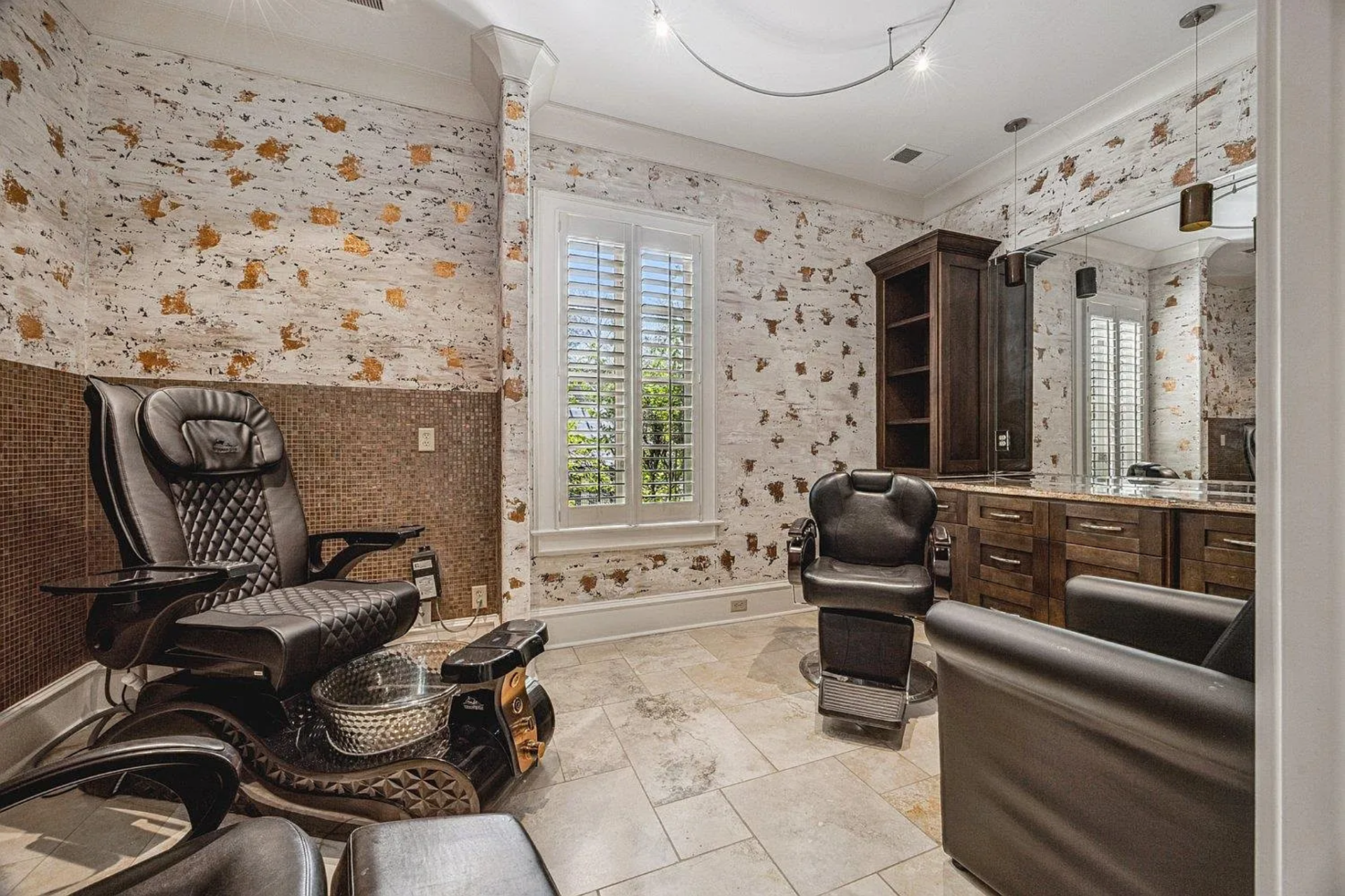 The salon provides a private, at-home grooming experience, which includes professional styling chairs and a built-in vanity for haircuts and a pedicure chair.