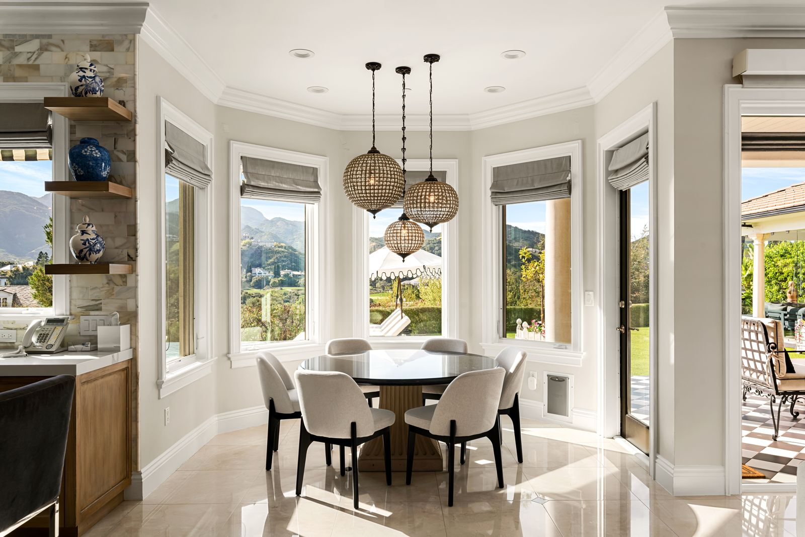 A round table sits just off the kitchen, surrounded by upholstered chairs and positioned to take full advantage of the backyard views.