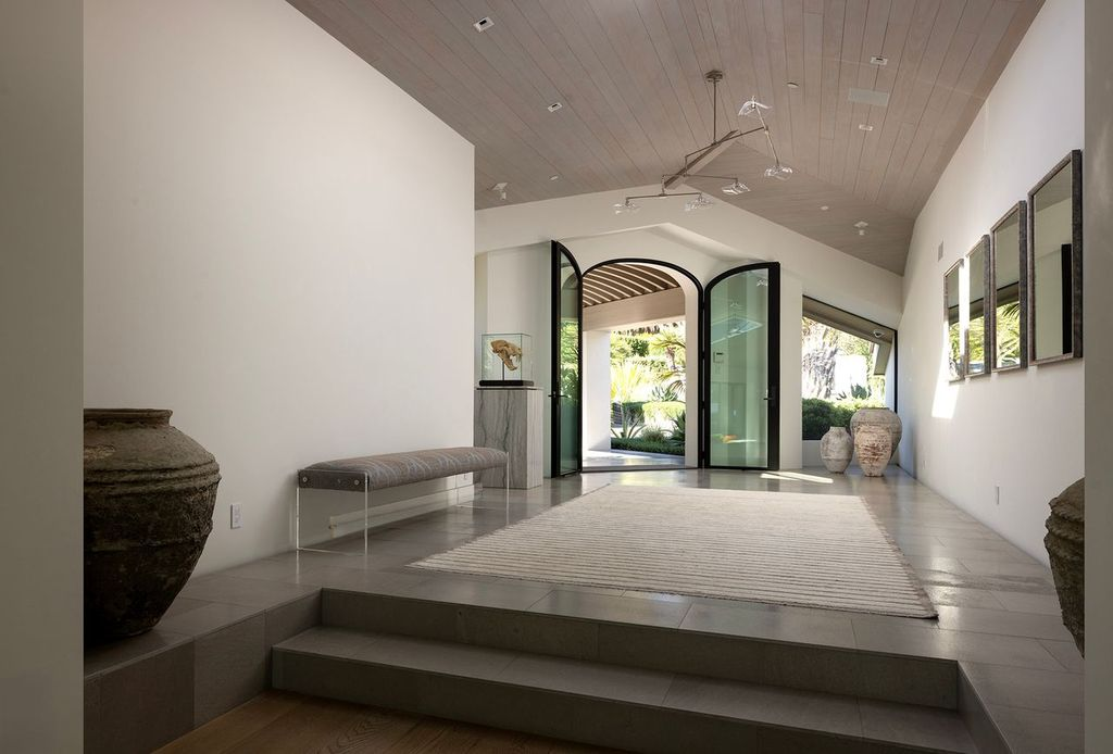 Right as you step through the double glass doors, the grand entryway sets the tone for the entire home with a wide open foyer set beneath a wood-paneled ceiling.