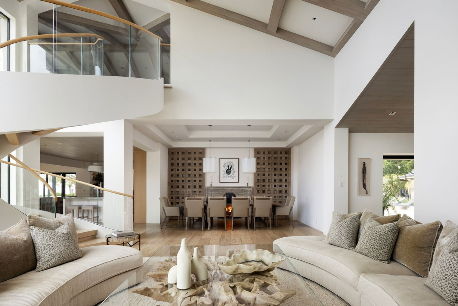 On either side, patterned wood paneling frames the fireplace wall and adds texture behind the dining chairs, while two pendant fixtures hang above the table.
