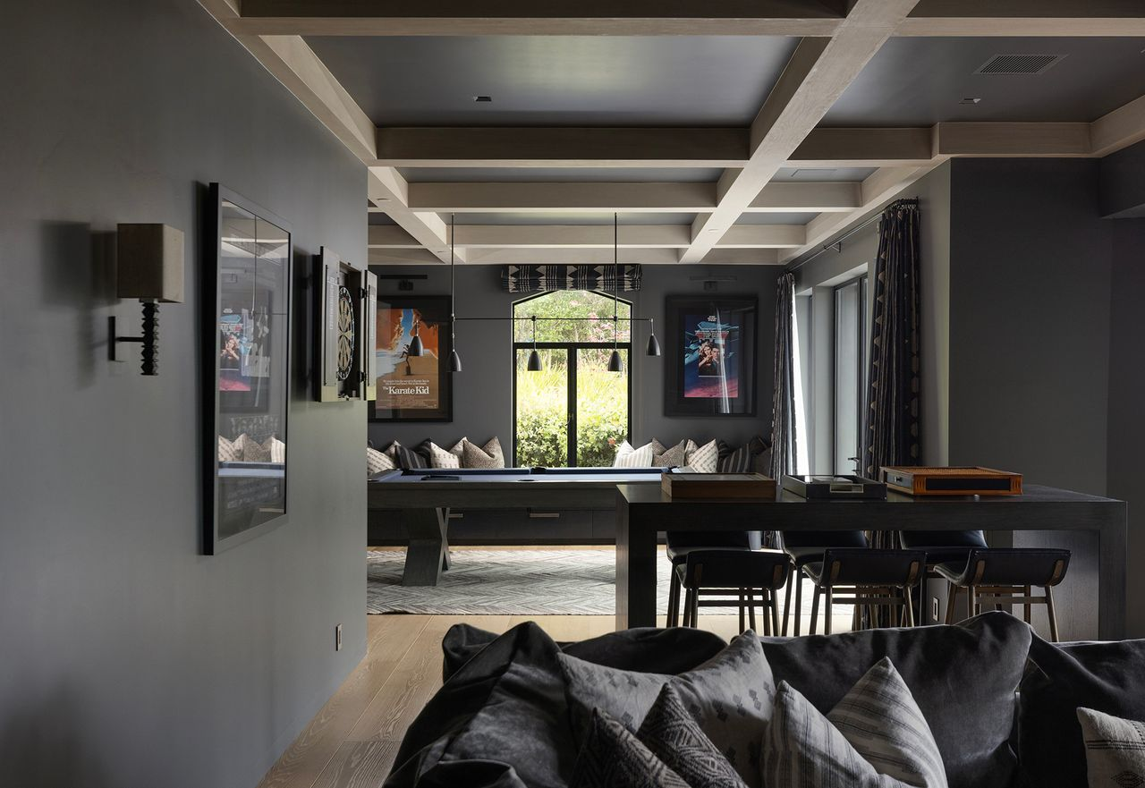 A billiards table sits in the middle of the room, while built-in banquette seating at the back creates a casual hangout area for spectators or conversation between games. 