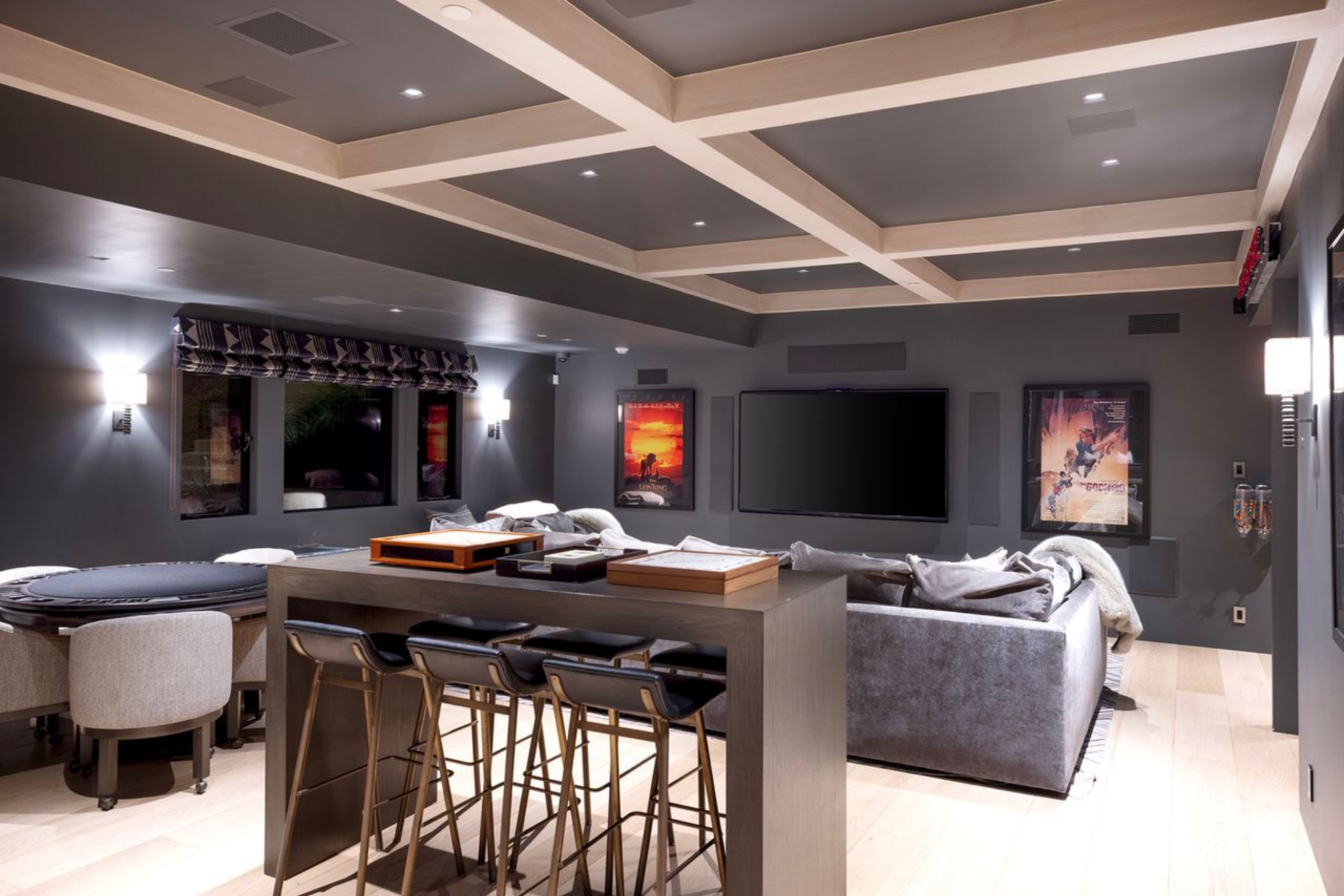 A large mounted TV sits at the far end, with sectional seating arranged in front of it.
