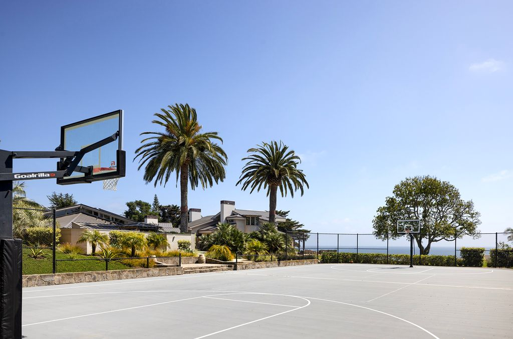 The court is enclosed with low fencing, and is set up to accomodate both basketball and tennis games.