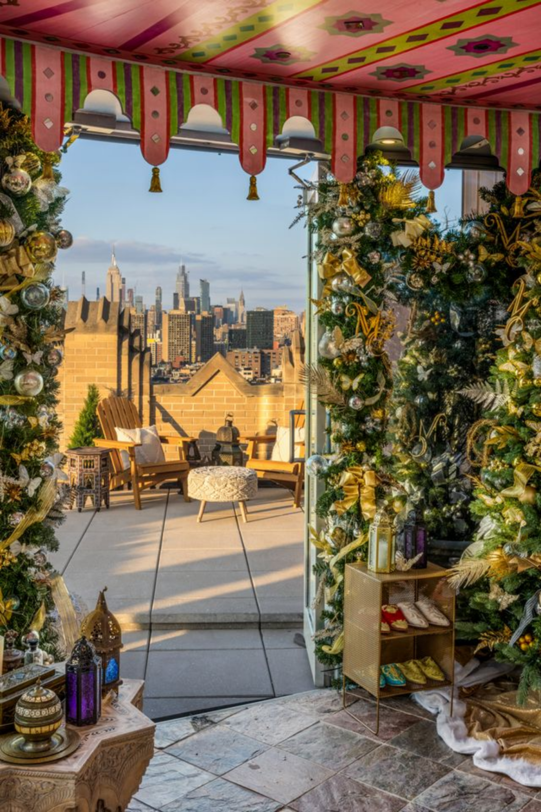 Glass walls keep the skyline in full view, while the room is layered with details such as decorated trees adorned with gold M's and butterflies, and the Moroccan-style decor placed around the edges.