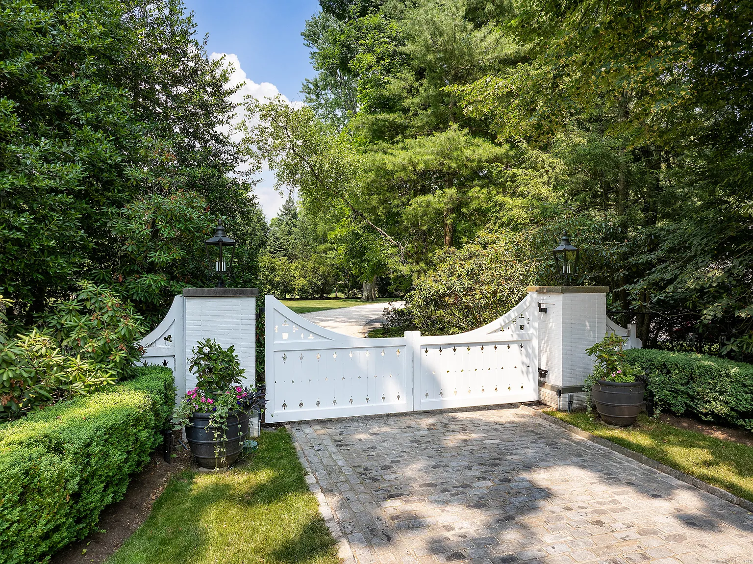 Set behind a white gate and approached by a long driveway, the estate is positioned across more than 11 acres of landscaped grounds. 