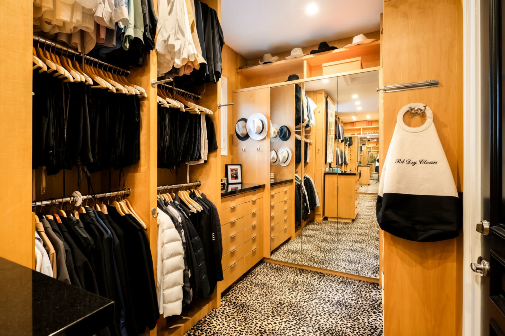 Moving on to the closets, the first one is lined in warm wood, with hanging space lining both sides and drawers integrated below. 