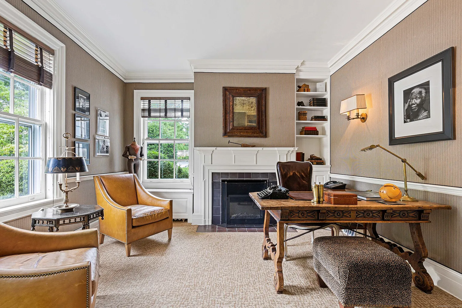 Off the main hall, the designer’s office is centered around a carved wood desk placed in front of the fireplace.