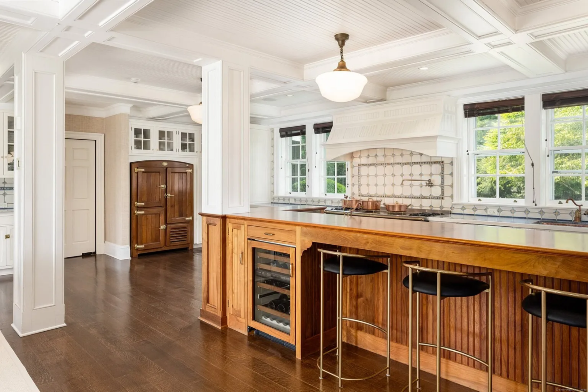 From the formal rooms, the house moves into a kitchen which opens up around a long central island that creates a natural spot for prep, serving, or casual seating.