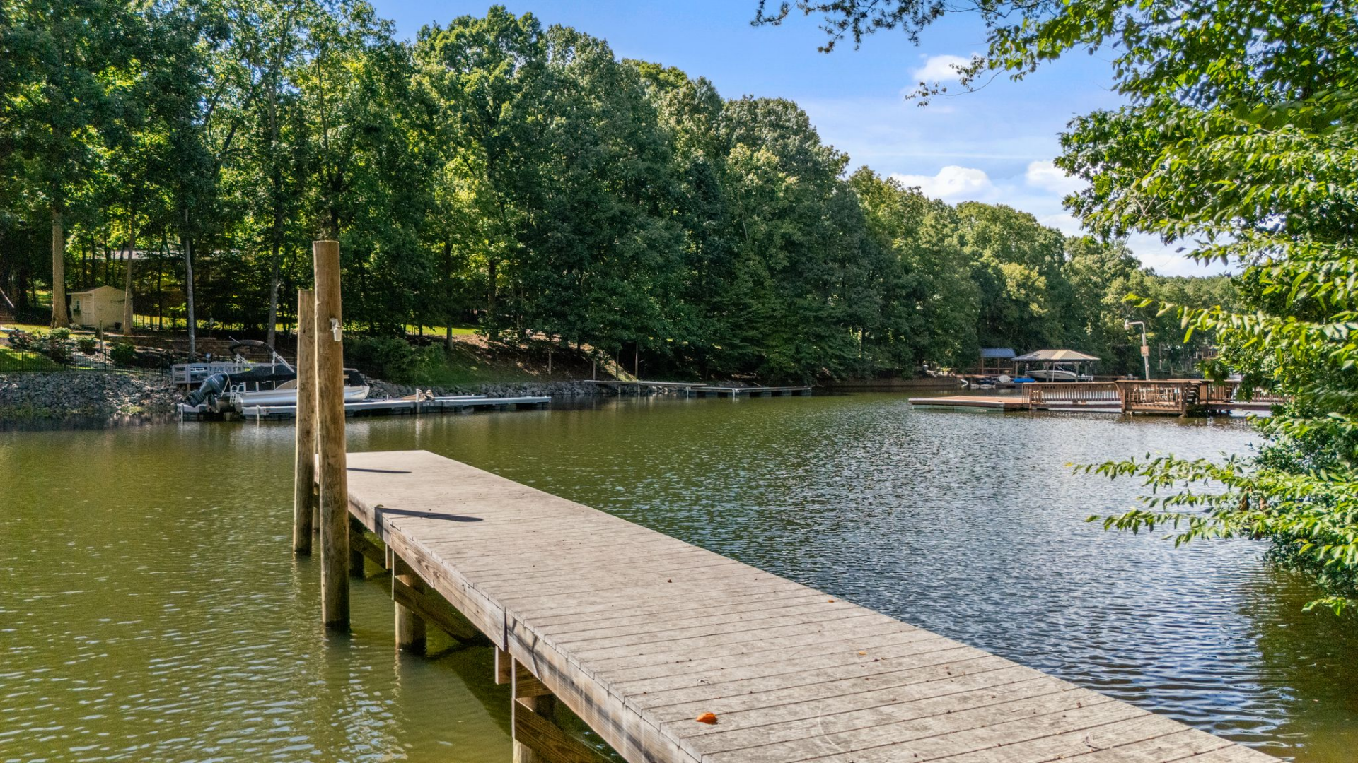 Moving further out, a path leads through the trees to the water’s edge, where a private dock extends straight out into the lake. 