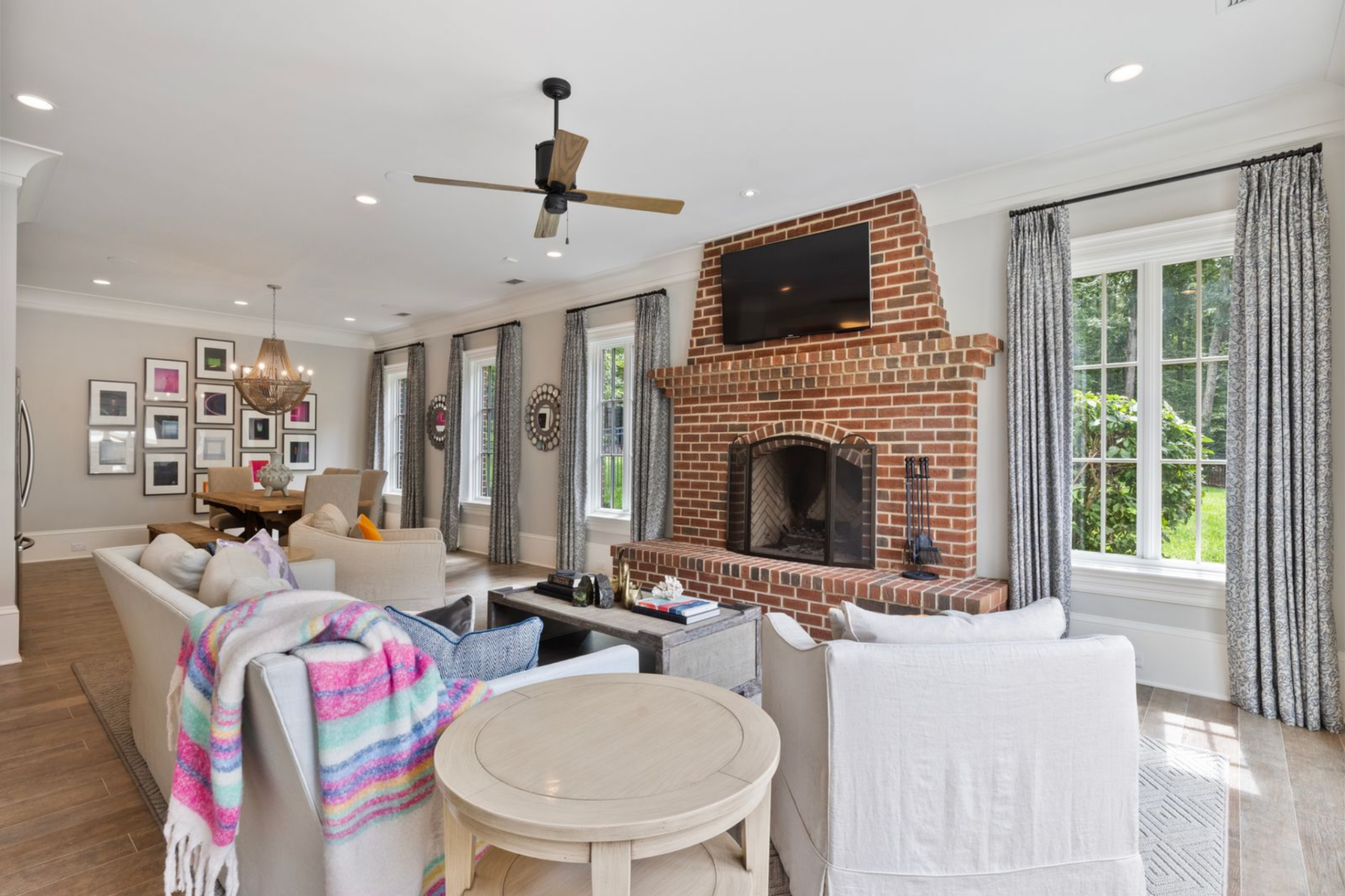 The main living area is centered around a brick fireplace that runs floor to ceiling, with a mounted TV above and a raised hearth.