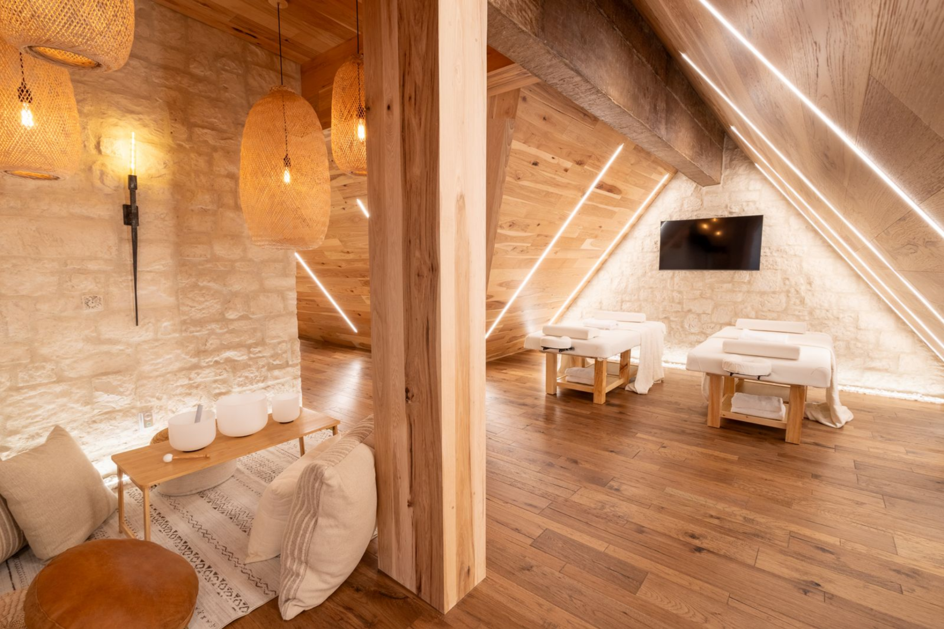 Off to the side, the spa corner is arranged as a softer lounge area with stone walls, woven pendant lights, floor cushions, and a low table, creating a place for sound healing.