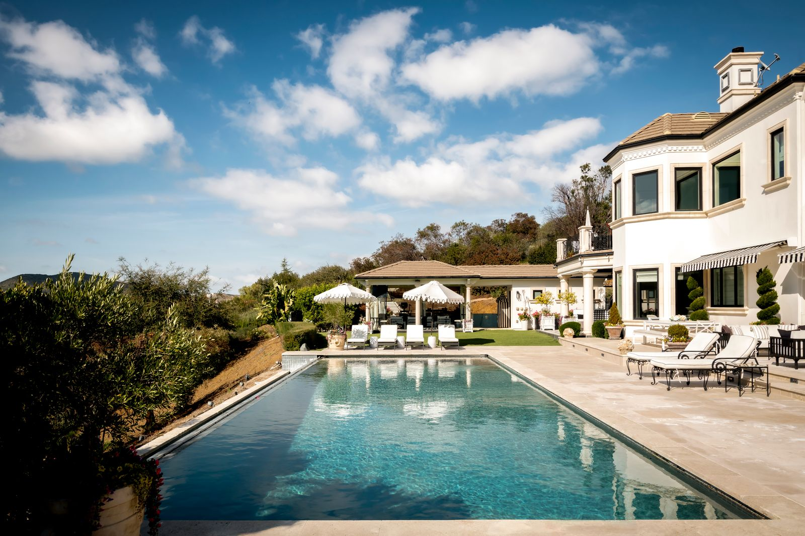 Beyond the terrace, the property opens to an infinity-edge pool that runs parallel to the home.