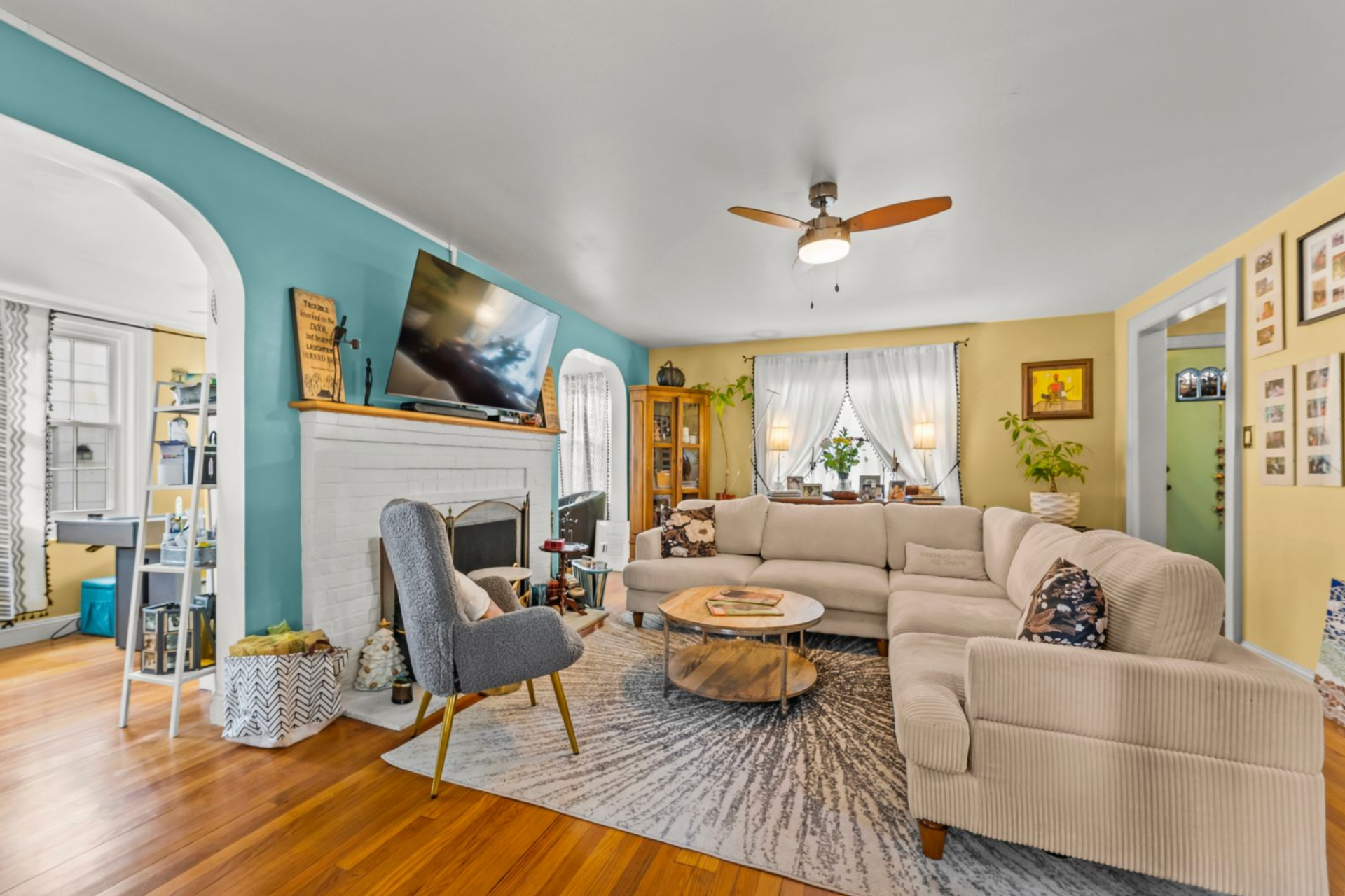 A large sectional sits over an area rug in the center, creating a main gathering space, while a single accent chair is pulled closer to the fireplace.