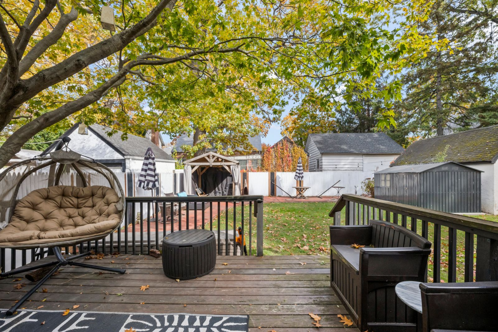 A paved section toward the back leads to a gazebo that serves as a secondary seating or lounge area on the same level as the lawn.