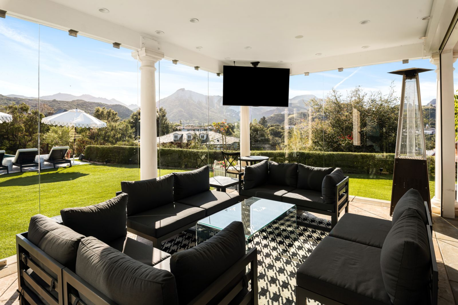 A separate covered lounge on the other side of the pool offers a more enclosed lounge area, wrapped in glass to preserve views while providing shelter from the outdoors. 