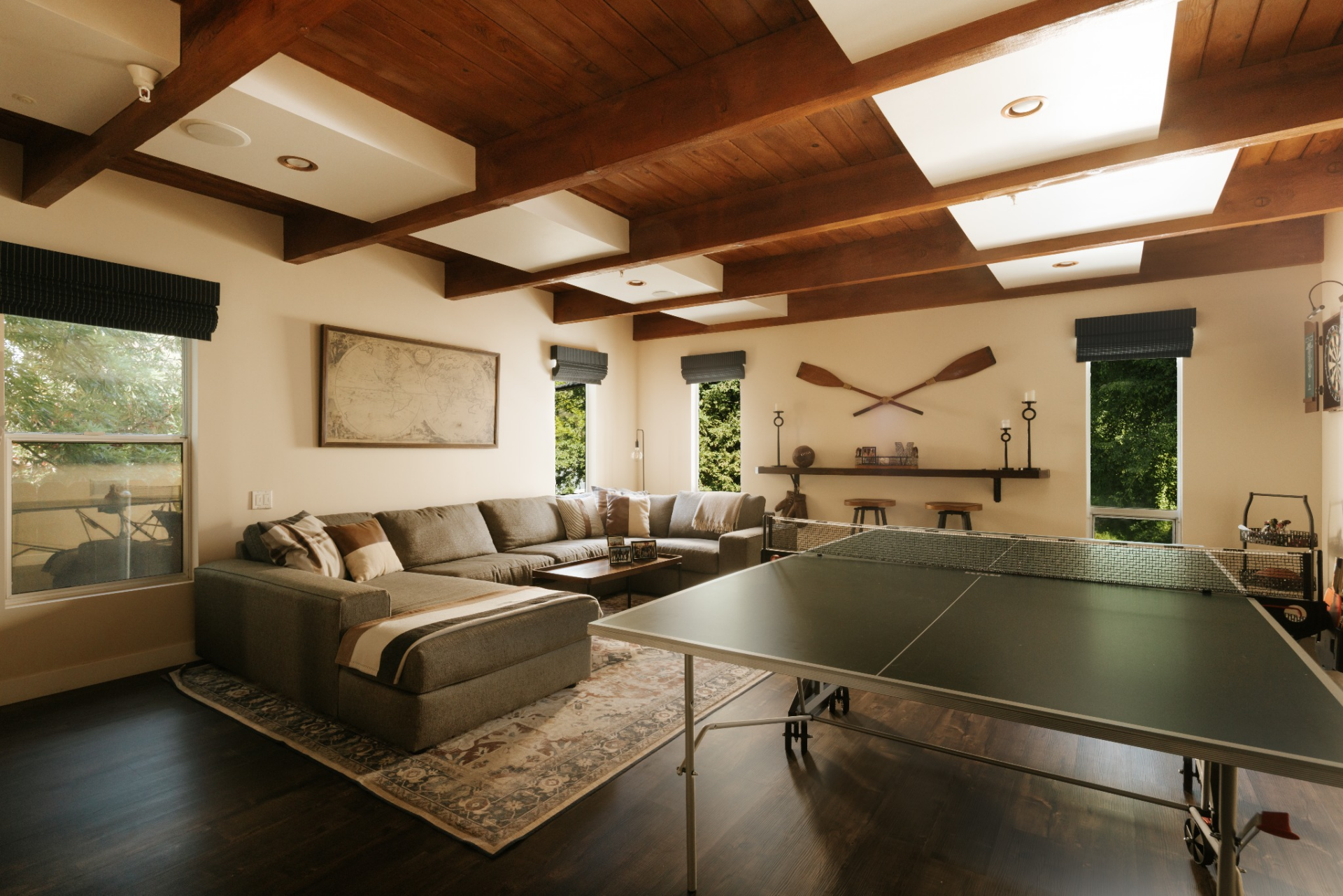 The game room is centered on a full ping-pong table, with a large sectional next to it creating a separate place to sit and watch without interrupting the game.