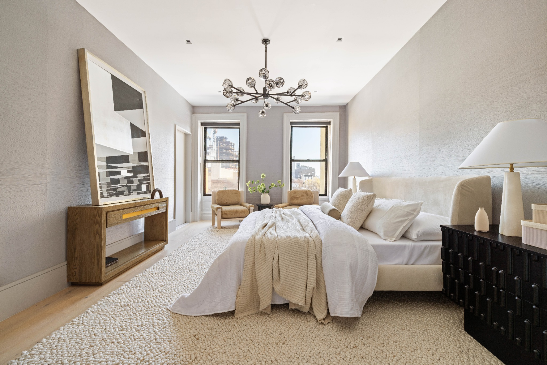 A soft, neutral palette fills the space, with low furniture and minimal detailing keeping the focus on the room’s height and natural light.