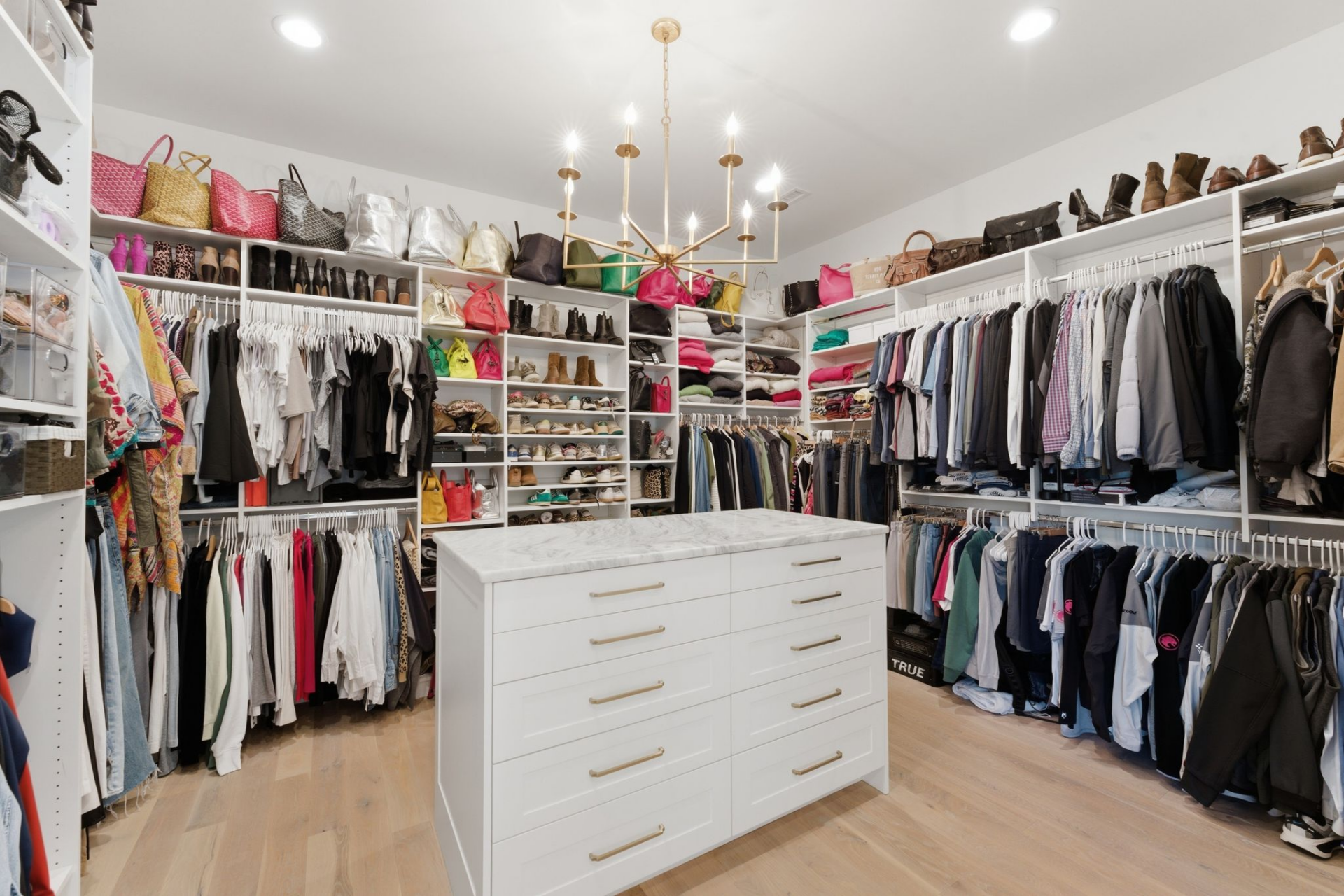 The closet is designed as a full dressing room, lined with open shelving, hanging space, and dedicated sections for shoes and accessories. 