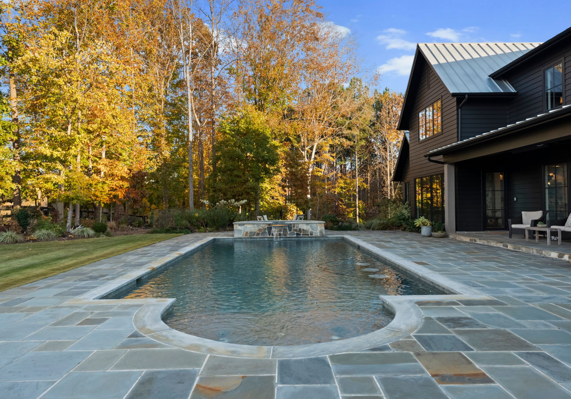 At the back of the main house, the backyard opens to a rectangular saltwater pool set within a wide stone terrace. 