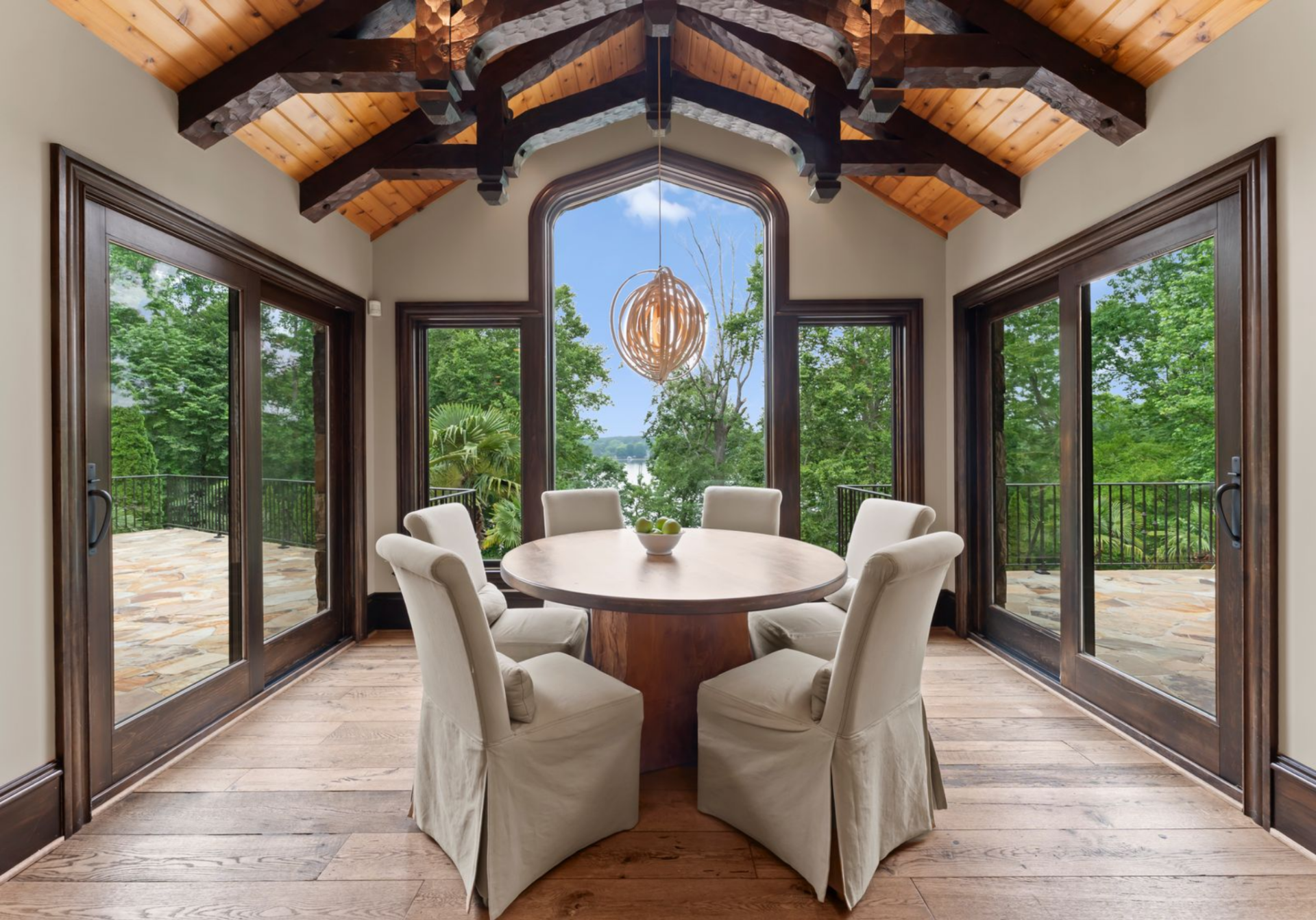Just off the great room, the casual dining space is wrapped in glass doors and tall windows that look out toward Lake Norman.