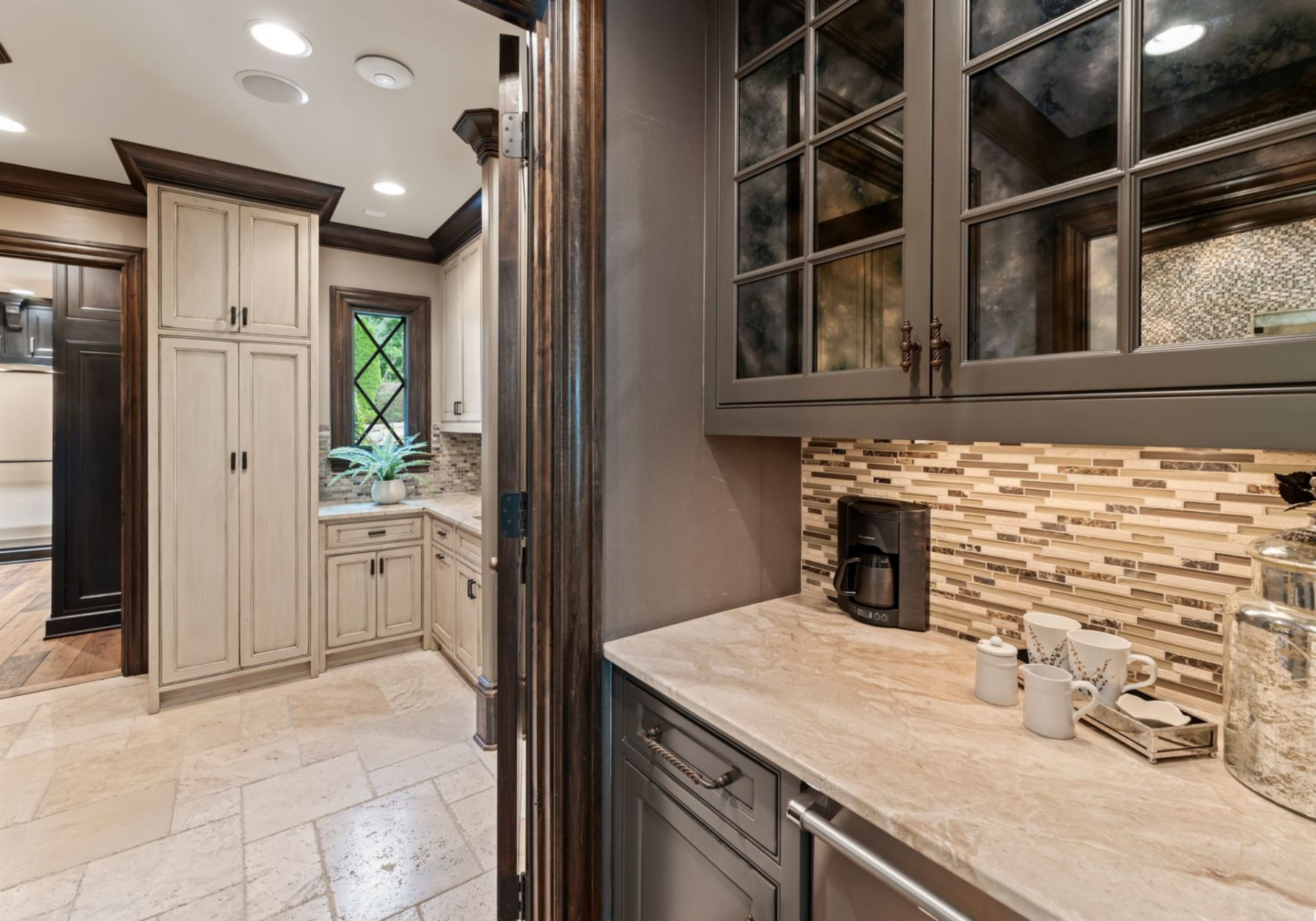 Just off the bedroom, a built-in coffee bar adds a functional layer to the suite, finished with stone countertops, custom cabinetry, and a tiled backsplash.