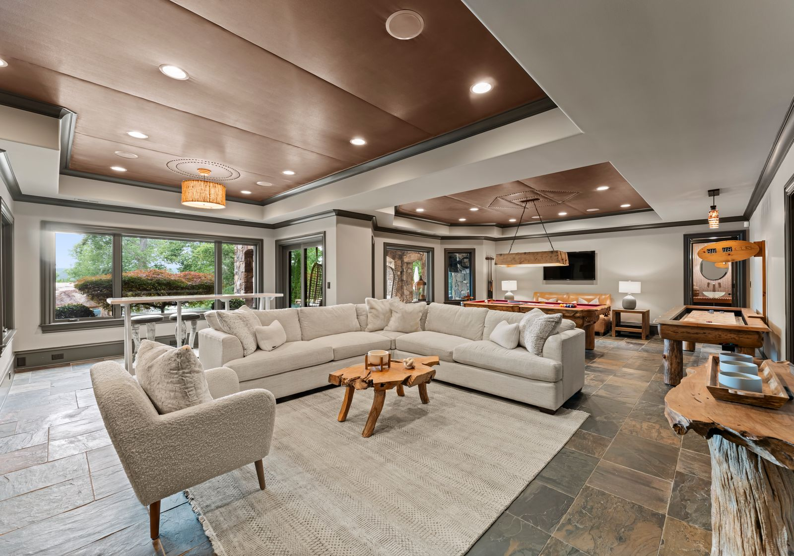 The level opens with a large game lounge starting with a white L-shaped couch just before the far side of the room, which has a red-felt pool table and an air hockey machine.