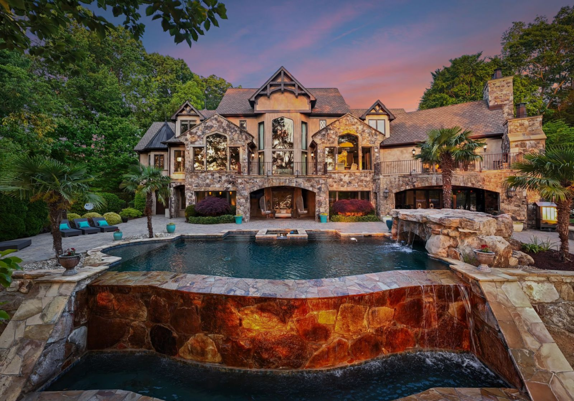 The pool anchors the backyard, designed with an infinity edge that drops into a lower catch basin.