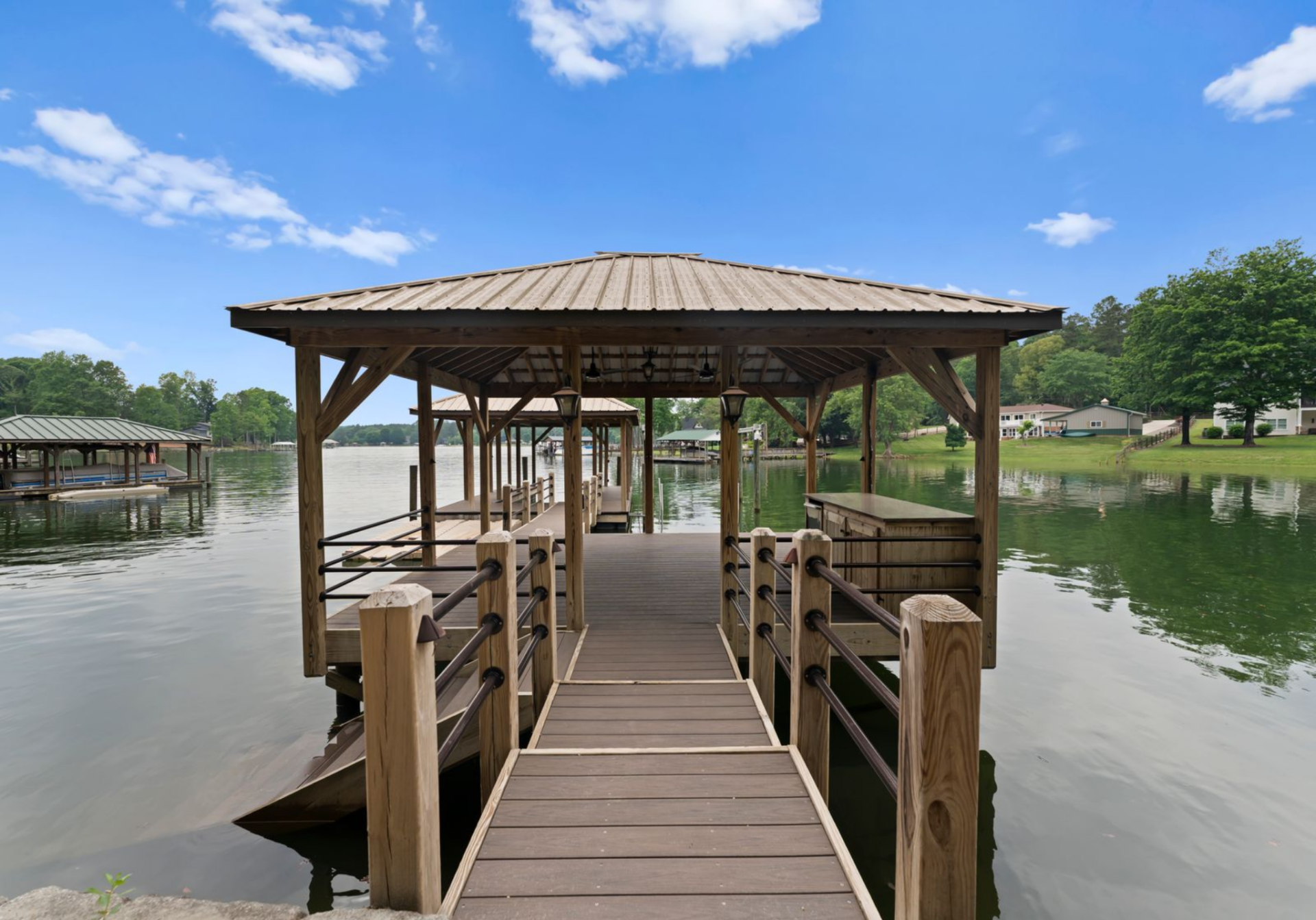 The dock includes a boat lift and seating area, providing direct access to the water while maintaining a sheltered space at the end of the pier.