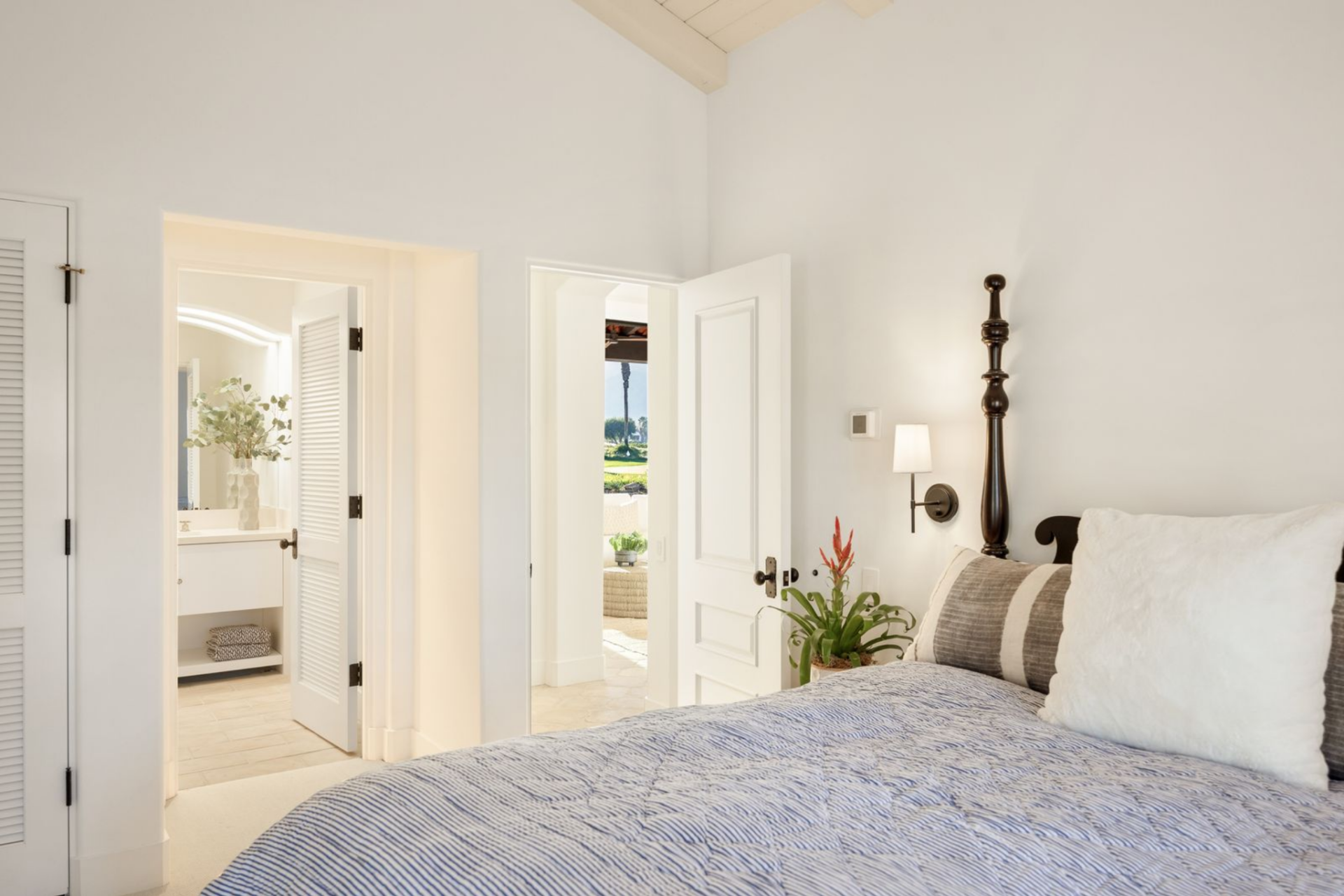 A third bedroom uses the same vaulted ceiling design, with shuttered French doors leading to the en-suite bathroom.