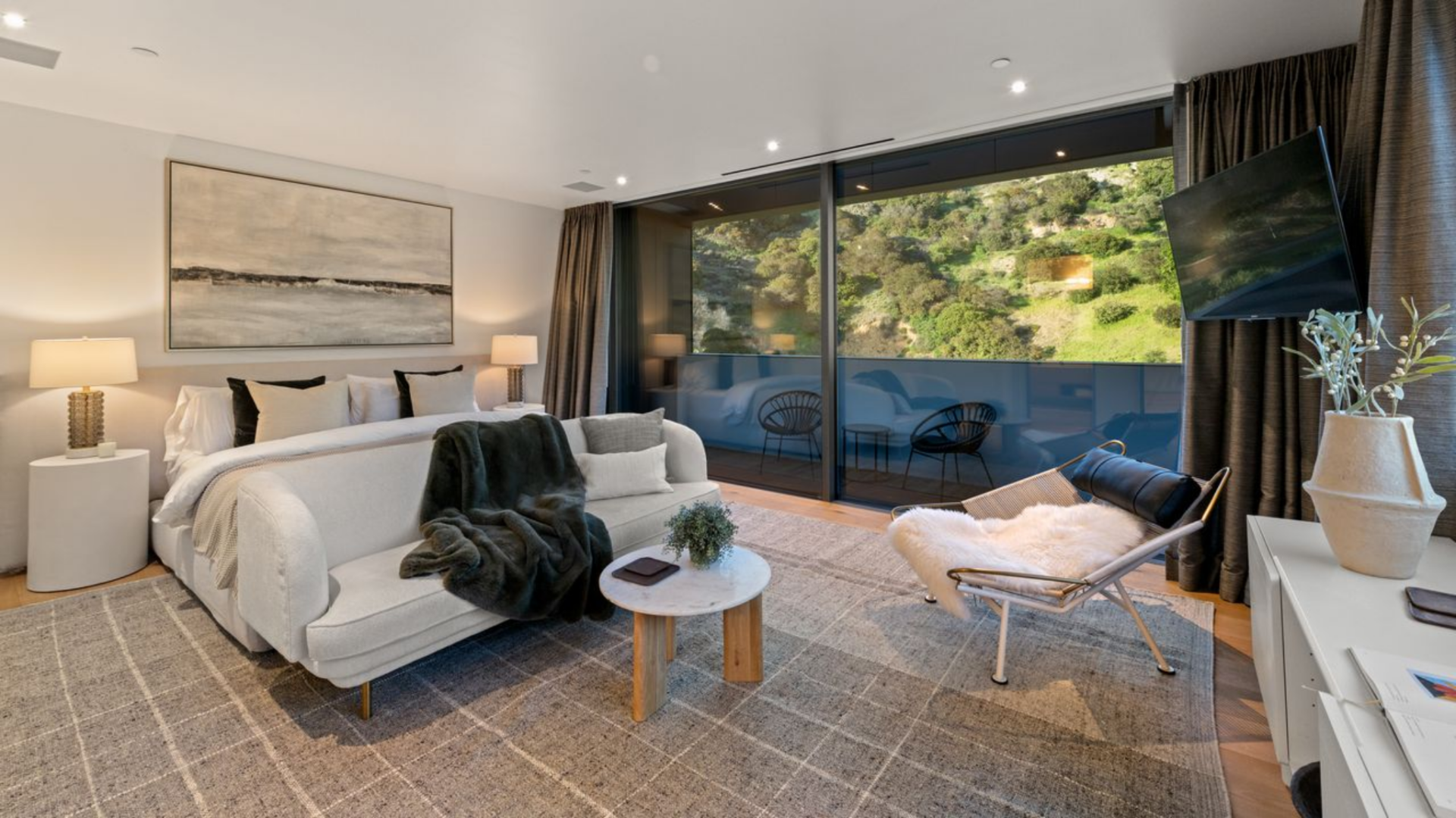 The third bedroom is arranged more like a junior suite, with the bed, sofa, lounge chair, and media console all sharing one open space.