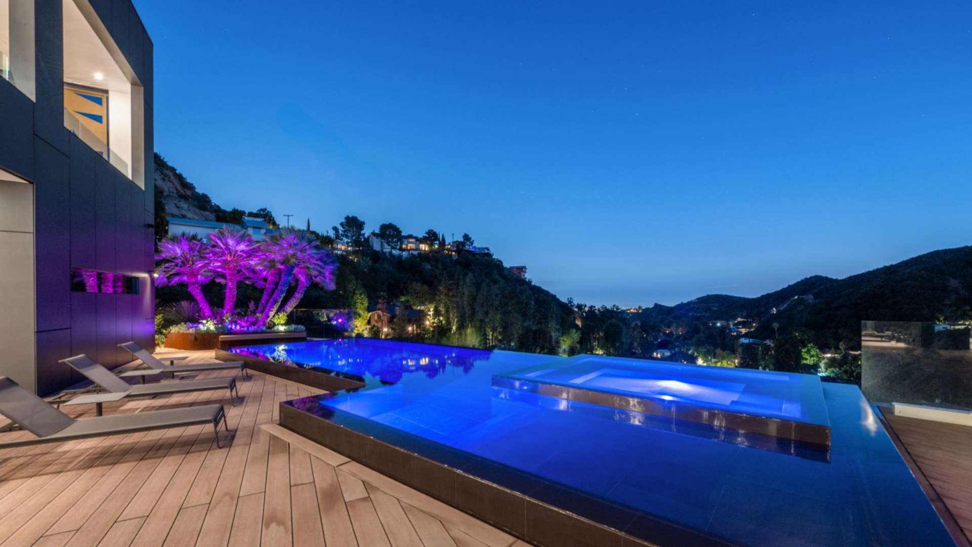 Beyond the patio, the deck leads to a 40-foot black-lined infinity pool set along the edge of the property.
