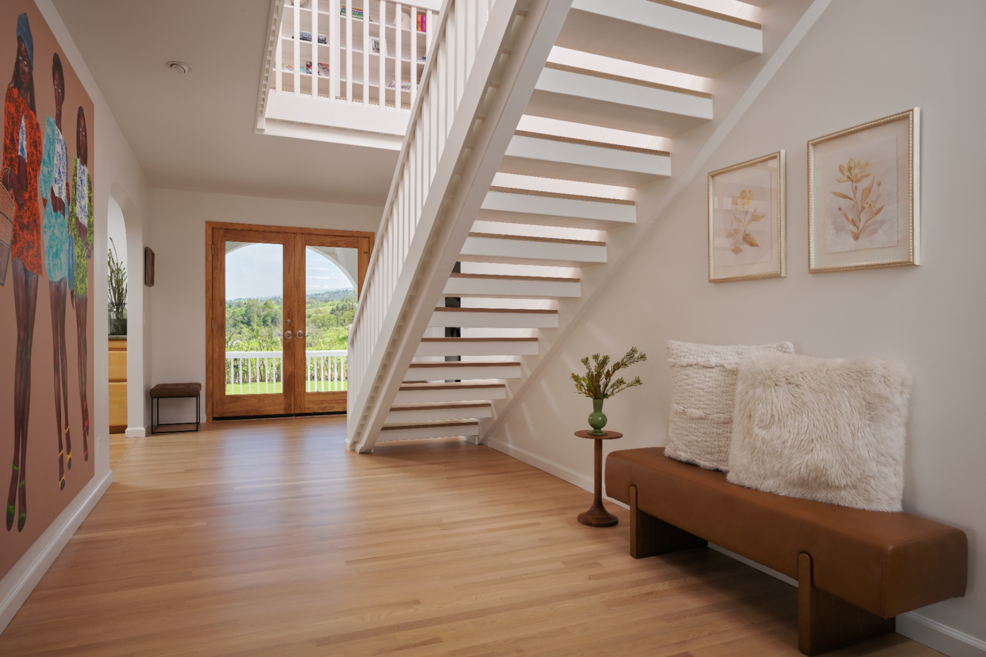 Light white oak flooring runs throughout the space, grounding the interior with a warm, natural finish while reflecting the daylight that moves in from multiple directions.