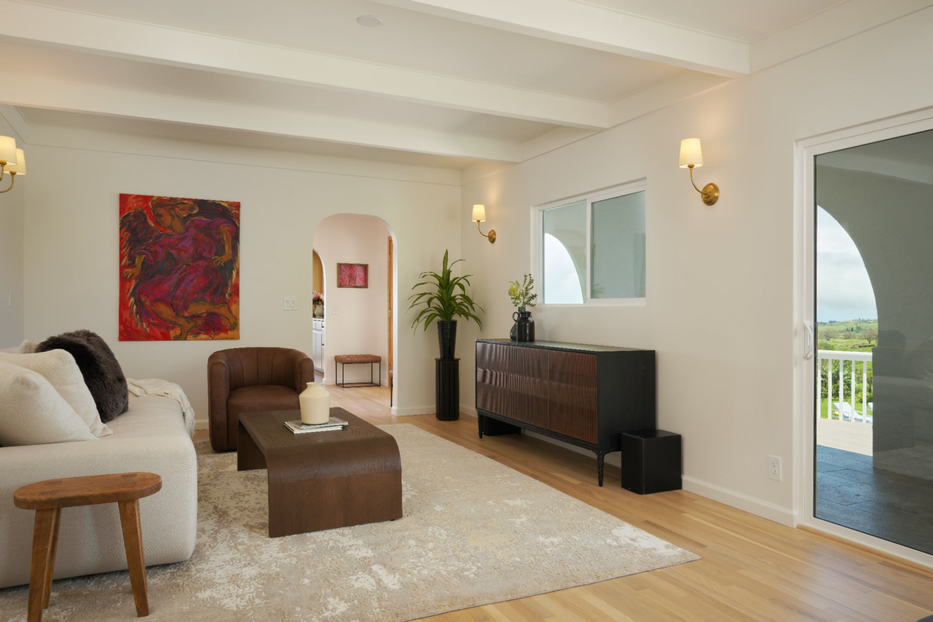 The room is arranged around a low sofa, leather chair, and wood coffee table, creating a more intimate sitting area just off the main entrance.