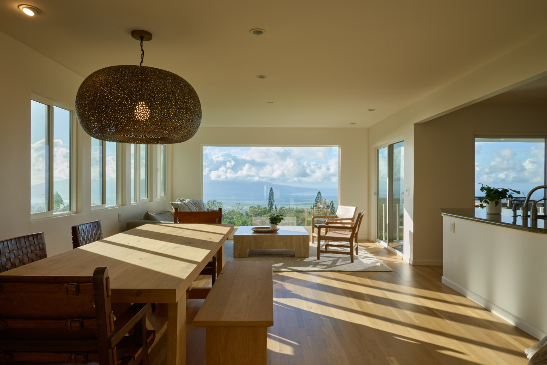 On the other side of the hall, the home opens into its main living space, where the dining area and lounge share one long, view-facing room. 