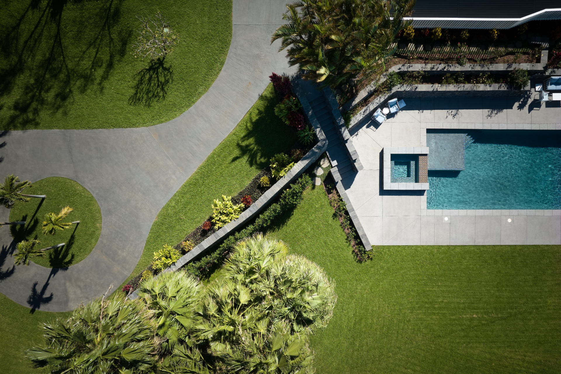 From above, the layout reveals a series of landscaped tiers and pathways that move through the property, with walking trails connecting different sections of the land. 