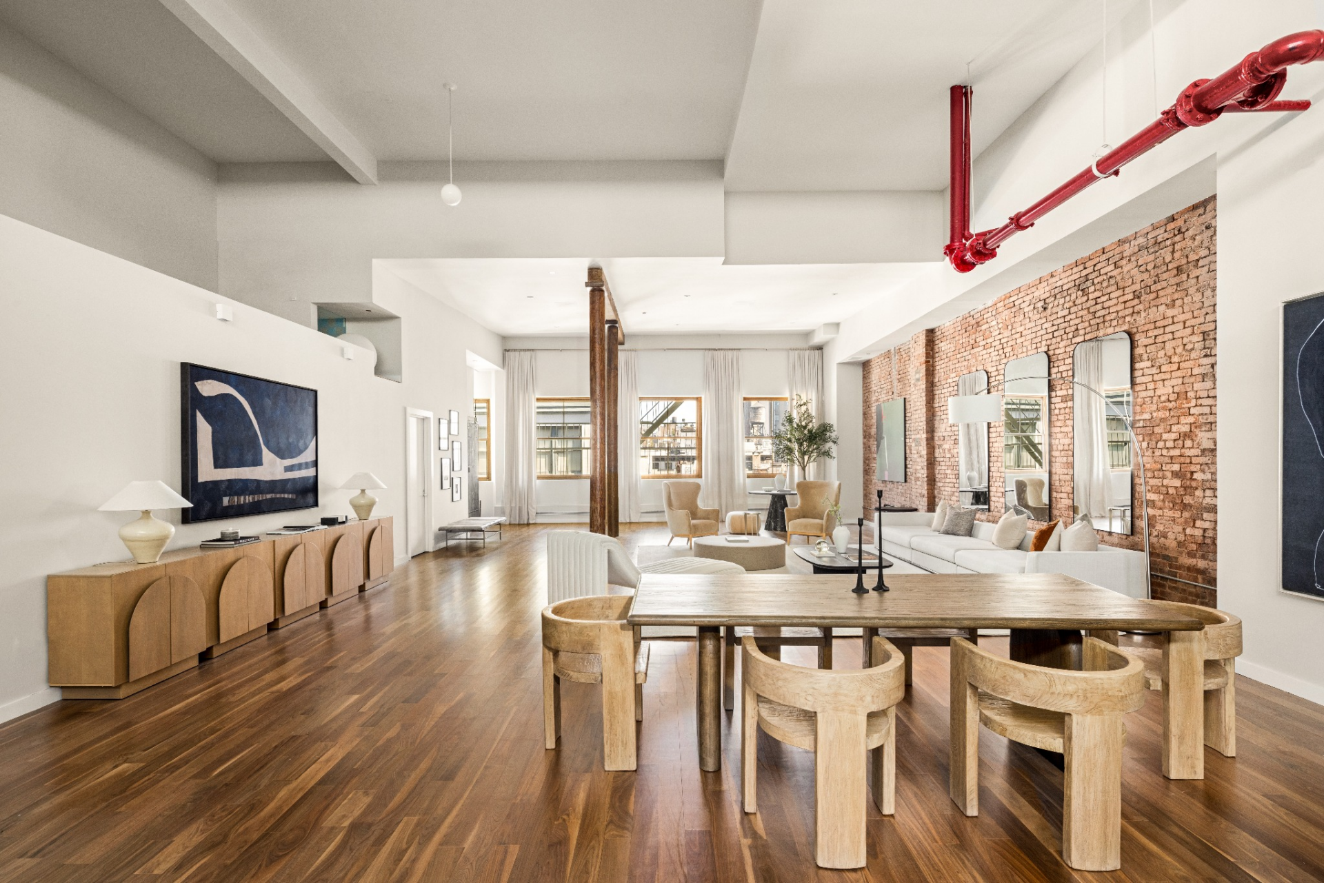 Within the space, a solid wood table with sculptural, curved chairs sits directly on the hardwood floors.